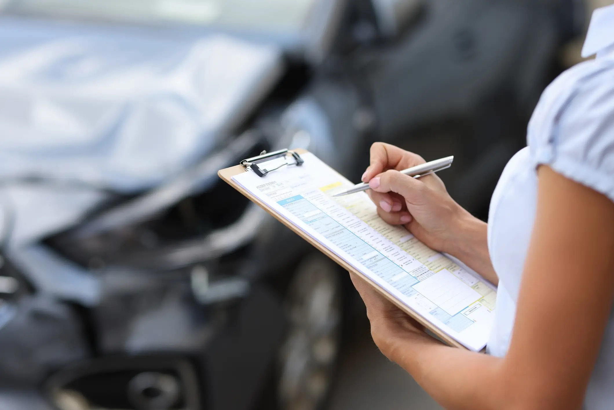 Insurance agent assessing car accident damage