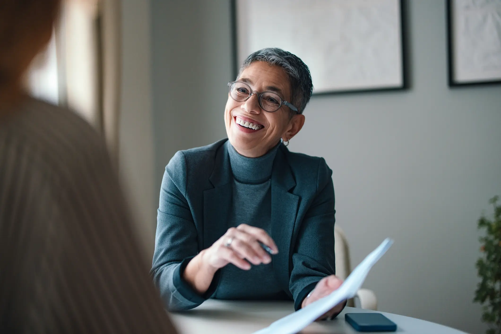 Woman holding document, smiling in conversation